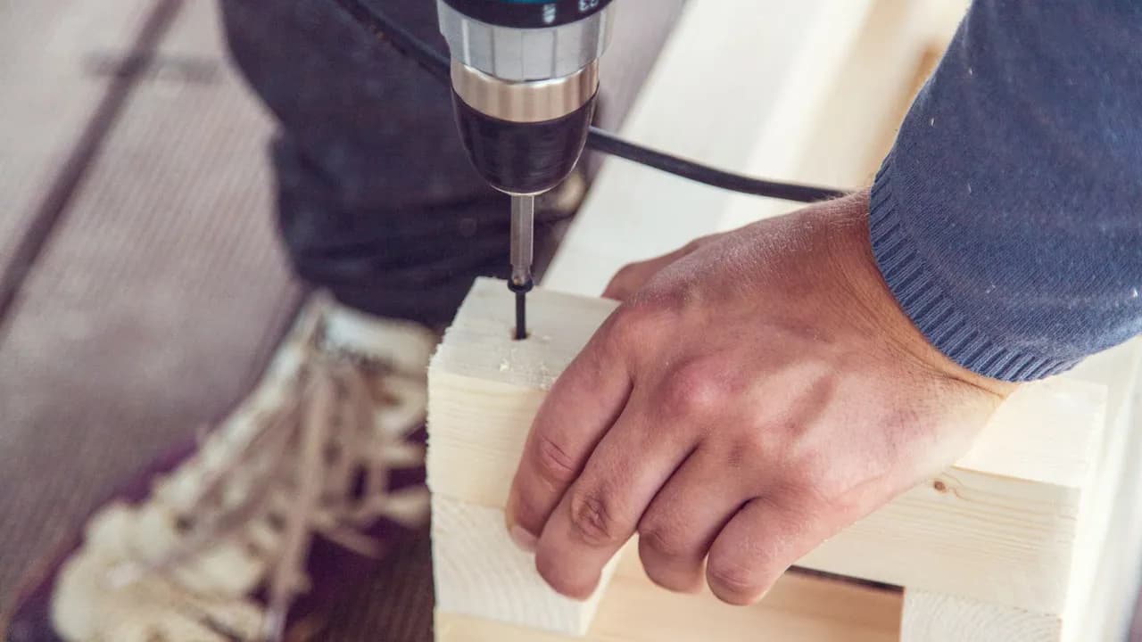 Perçage d'un avant-trou dans une planche à la visseuse