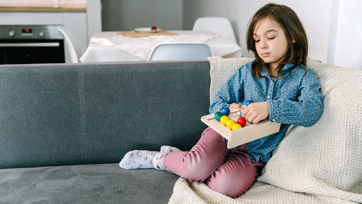 Enfant jouant assis sur un canapé