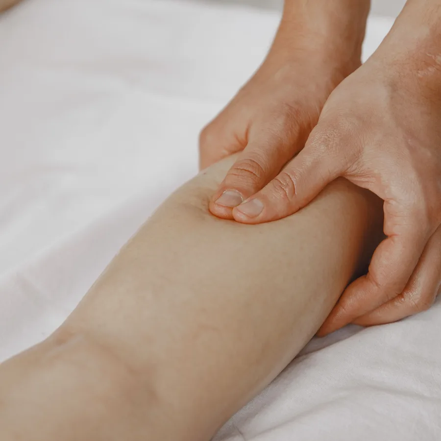 Mains massant un mollet