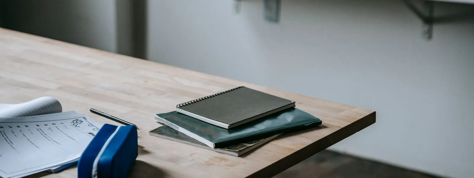 Bureau d'écolier avec des cahiers, une trousse et un stylo